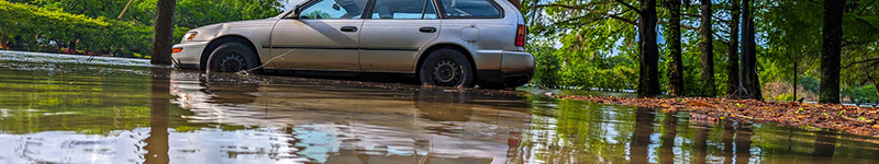 A flood is starting to drown an old car